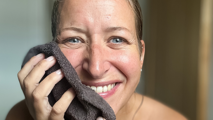 Natural skincare for perimenopause: Lotus Light Cream and tin scoop beside a towel