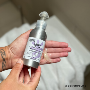 Hand holding a 100g bottle of Lotus Cleansing Gel with a pump of gel